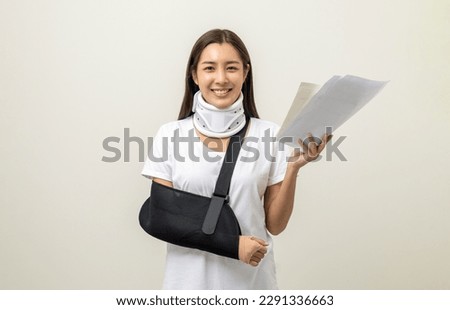Asian woman broken arm and leg holding bill payment. woman put on plaster cast splint with walking sticks crutches. Patient wearing sling support arm with neck collar. life insurance and accident Royalty-Free Stock Photo #2291336663