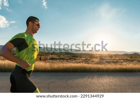 Triathlete in professional gear running early in the morning, preparing for a marathon, dedication to sport and readiness to take on the challenges of a marathon.  Royalty-Free Stock Photo #2291344929