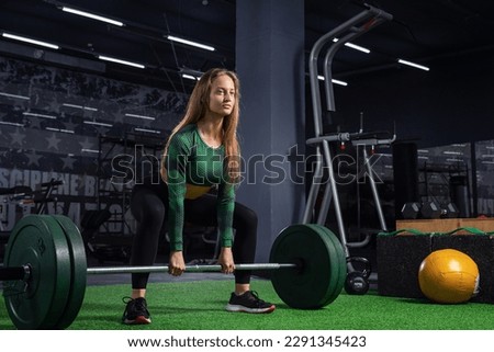 Young woman  with bar flexing muscles in the gym. Sport, fitness, teamwork, bodybuilding and people concept Royalty-Free Stock Photo #2291345423