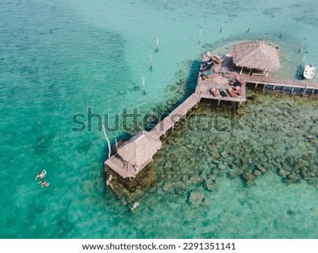 Hidden bar in sea, walking from beach by wooden bridge, range of coral and rock for snorkeling