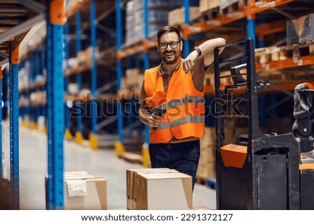 A storage worker is preparing to use bar code reader to load goods on shelves. Royalty-Free Stock Photo #2291372127
