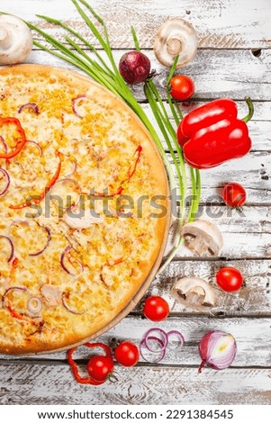 Pizza with chicken, paprika and corn. Italian kitchen and cooking concept. Chief with a pizza cutter cutting pizza to pieces at Neapolitan pizzeria.