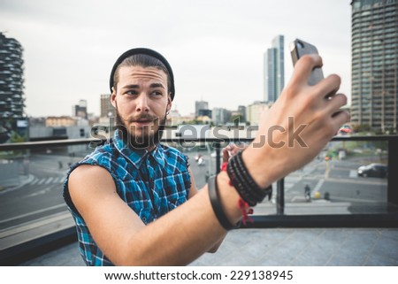 young handsome bearded hipster man selfie in the city