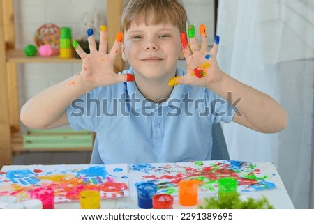 Boy paint fingers drawing baby painting hand therapy children art play. Kids have fun and create picture. Palms of different colors. Sensory development and experiences