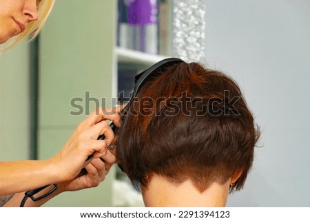 real female haircut in a beauty salon. female hairdresser and client. women's business. drying and styling hair with a hairdryer. close-up