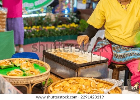 Chef flip coconut cake on oven in street food market.