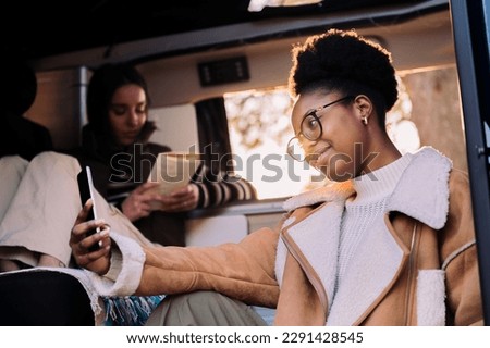 smiling african woman taking selfie in camper van