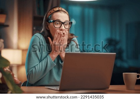 Stressed panicked woman working with her laptop at home, she is having computer problems: system failure and virus infection concept Royalty-Free Stock Photo #2291435035