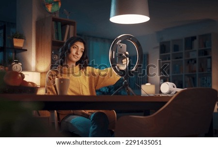 Young vlogger and content creator shooting a video for her followers, social media and communication concept Royalty-Free Stock Photo #2291435051