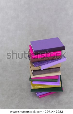 stack of books and book on grey background. space for text