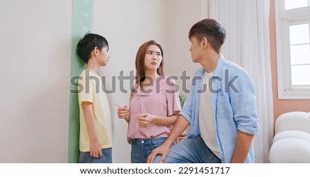 asian parents help their boy doing height measurement with worry about his shortness make them a bit depression Royalty-Free Stock Photo #2291451717