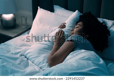 Young woman sleeping in soft bed at night Royalty-Free Stock Photo #2291452237