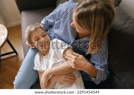 Mother and son plays tickle at home on the sofa living room. Happy motherhood and childhood Royalty-Free Stock Photo #2291454549