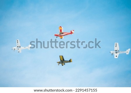 The photo depicts 4 airplane flying in a clear blue sky. The airplane looks very elegant with its contrasting white and red colors and sleek aerodynamic lines. Its wings are spread wide, s