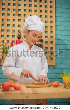 Vertical picture of beautiful asian female chef use a knife were precise and deliberate showing her years of experience in the kitchen full of cooking ingredients.