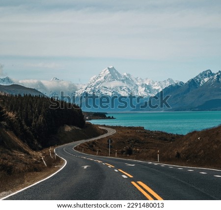 Aoraki Mount Cook, road and turquoise lake Pukaki view from Peter s Lookout, South Island, New Zealand. Warm colours, clear sky, snowy mountain tops. Iconic scenic New Zealand photo. Royalty-Free Stock Photo #2291480013