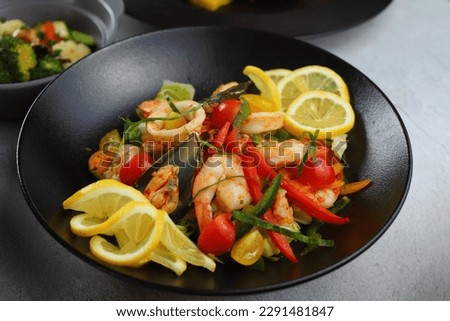 Seafood Salad Salad with prawns, mussels, squids, onions and spring onions decorated by lemon and parsley. Royalty-Free Stock Photo #2291481847