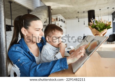 Mother reads a story to her son from a fairy tale book at home in the living room
