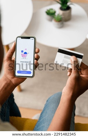 Crop person with smartphone paying with card
