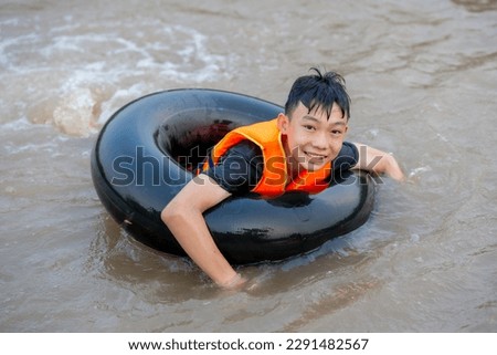 Kid boy playing water in pond