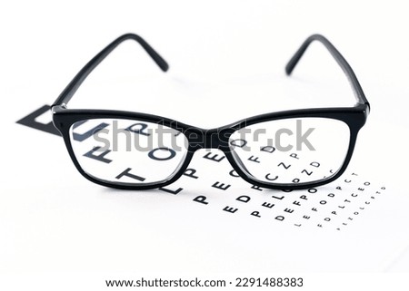 Eyeglasses with eye test table on white, optometrist concept and eye test Royalty-Free Stock Photo #2291488383