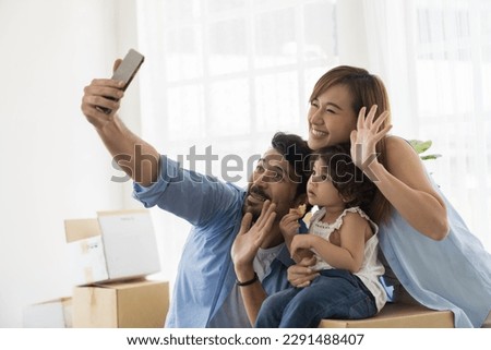 Moving house, mortgage, family and real estate concept. Happy family, father, mother and cute little daughter baby toddler girl playing and take photo while moving into new house
