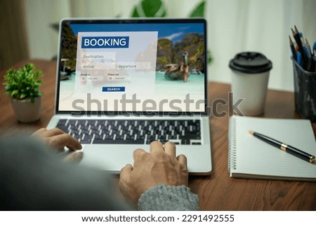 Online booking platform on a laptop computer by a person. Man use websites to search for accommodation, hotels and airlines for their vacation trips or buy tours on the Internet. Royalty-Free Stock Photo #2291492555