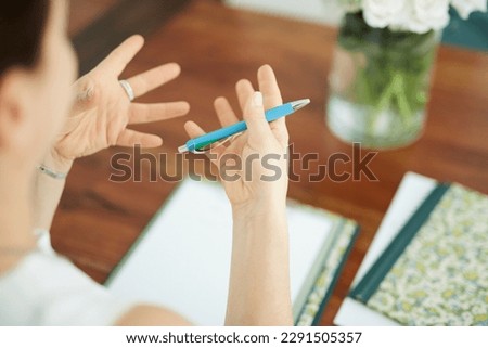 gesticulating hands with pen and clipboard at a table in office  Royalty-Free Stock Photo #2291505357