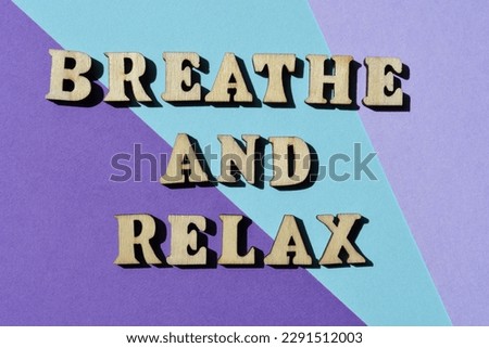 Breathe and Relax, words in wooden alphabet letters isolated on purple background as banner headline