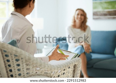 Counseling or therapy session with psychologist or doctor and client in office or practice room Royalty-Free Stock Photo #2291512983