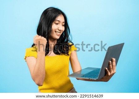 Portrait, Asian girl, holds laptop computer in hand, standing in meeting with group companies video call was delighted when received compliment from boss, Isolated indoor studio on blue background.