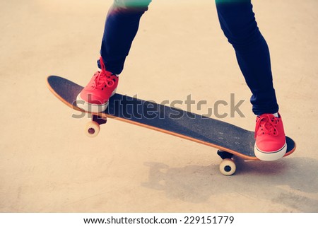 young woman legs skateboarding at skatepark 