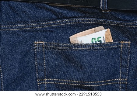 Banknotes in the back pocket of blue jeans. Save money concept. closeup of photo. Business background