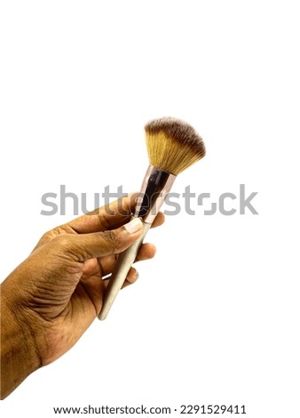 a hand holding makeup brush isolated on white