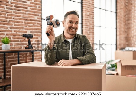 Young caucasian man smiling confident packing cardboard box at new home