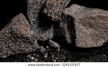 Macro Close up image of raw material Platinum and Chrome Ore rock isolated on black reflective background