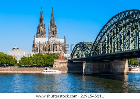 Cologne Cathedral and Hohenzollern Bridge through Rhine river in Cologne, Germany Royalty-Free Stock Photo #2291545111