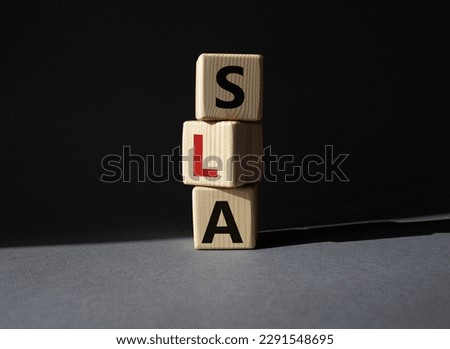 SLA - Service Level Agreement. Wooden cubes with word SLA. Beautiful grey background. Business and Service Level Agreement concept. Copy space.