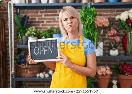 Young caucasian woman working at florist holding open sign skeptic and nervous, frowning upset because of problem. negative person. 