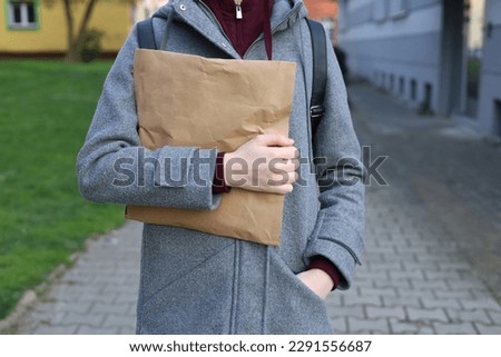 The girl holds a paper package in her hands. Parcel in hand. Shipment delivery. Delivery. The courier service is working. The order has been delivered.  Royalty-Free Stock Photo #2291556687