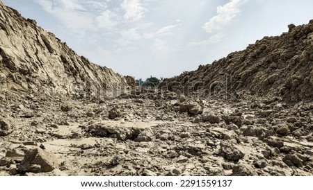 A kaccha valley road of rocky soil in the summer heat. Road is is made hard soil and not suitable to good transportation. Royalty-Free Stock Photo #2291559137