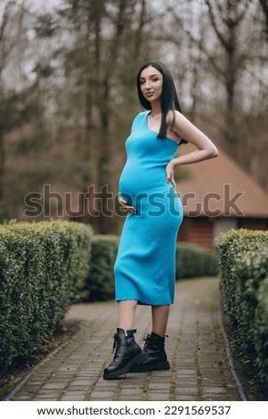 A modern pregnant woman, smiling, happy to be pregnant.