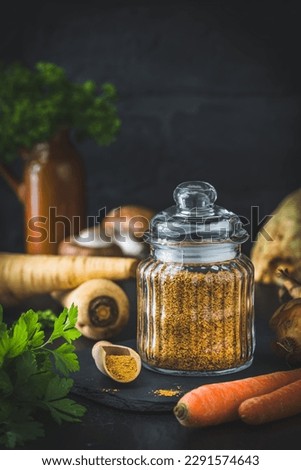 Homemade vegetable broth powder, organic vegetable stock, with raw vegetables on black background, vertical with copy space