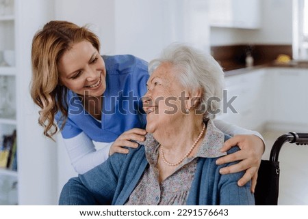 Portrait of nurse and her senior client on wheelchair. Royalty-Free Stock Photo #2291576643