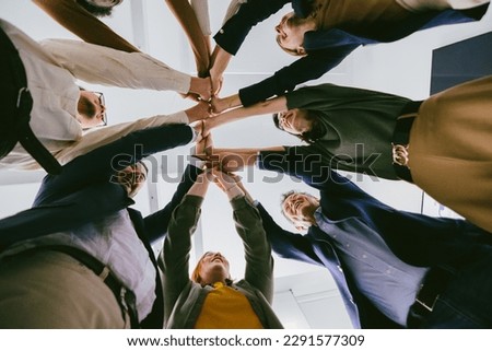 bottom view of united colleagues standing In circle holding hands together - teambuilding in business Royalty-Free Stock Photo #2291577309
