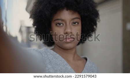 African american woman making selfie by camera with relaxed expression at street