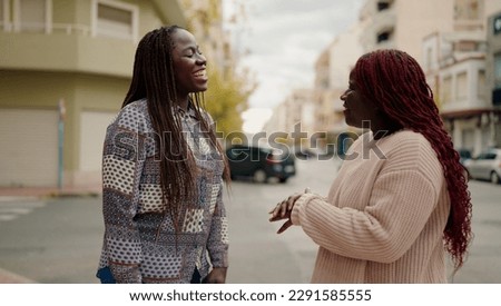 Two african american friends smiling confident standing together speaking at street