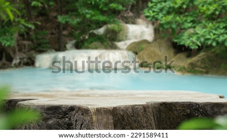 Wood table top podium floor in outdoor waterfall green tropical forest nature background.Natural water product present placement pedestal counter display, spring summer jungle paradise concept.