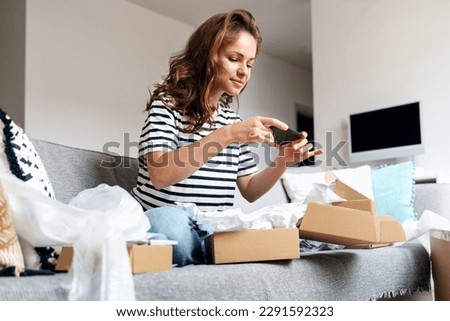 Woman taking picture of online purchase for leaving feedback about delivery and goods. Rating postal service, online shopping expirience.