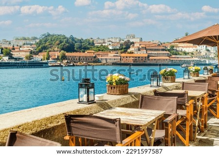 View of open-air street cafe on the banks of the River Douro in Porto, Portugal Royalty-Free Stock Photo #2291597587